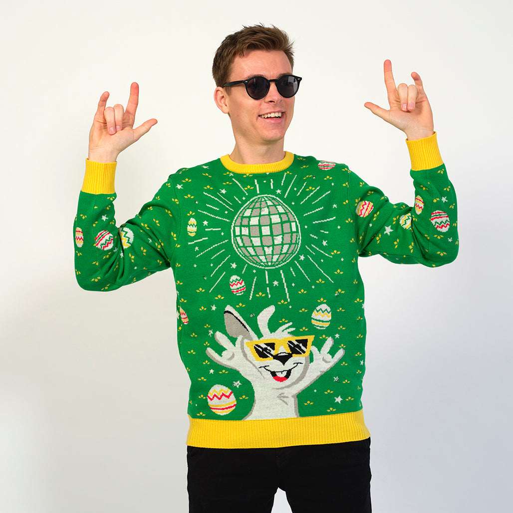 En festlig mand i solbriller med en påskesweater med en påskehare, der fester under en discokugle.